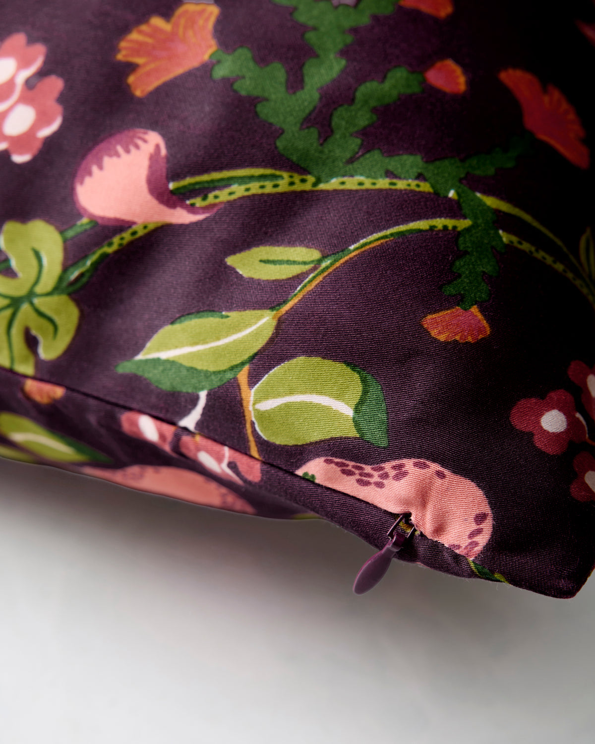 Close-up of the Plum Pomme & Poire pillowcase fabric and zipper corner.