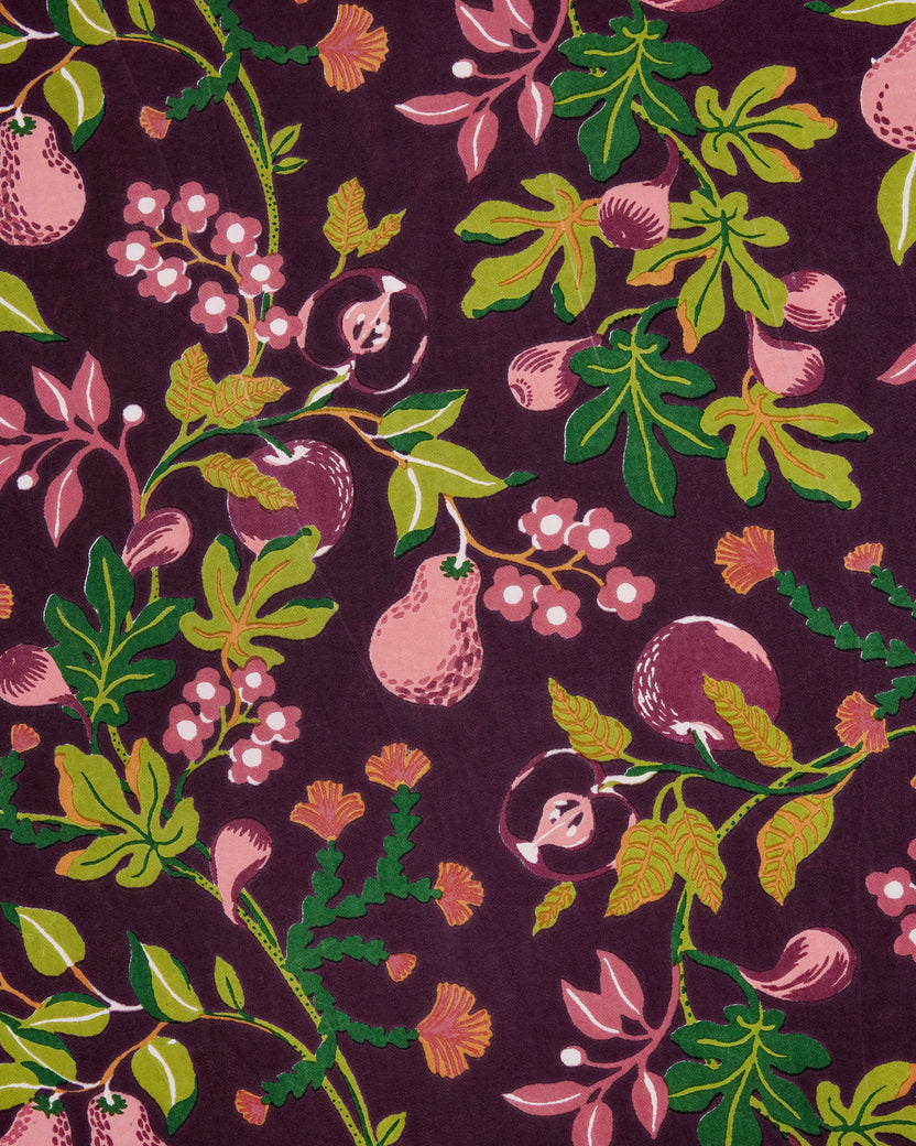 Close-up of the Pomme & Poire apron’s plum fabric print with fruit, flowers, leaves, and vines.