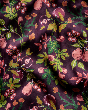 Close-up of the plum Pomme & Poire pajama print with pears, apples, berries, leaves, and flowers.