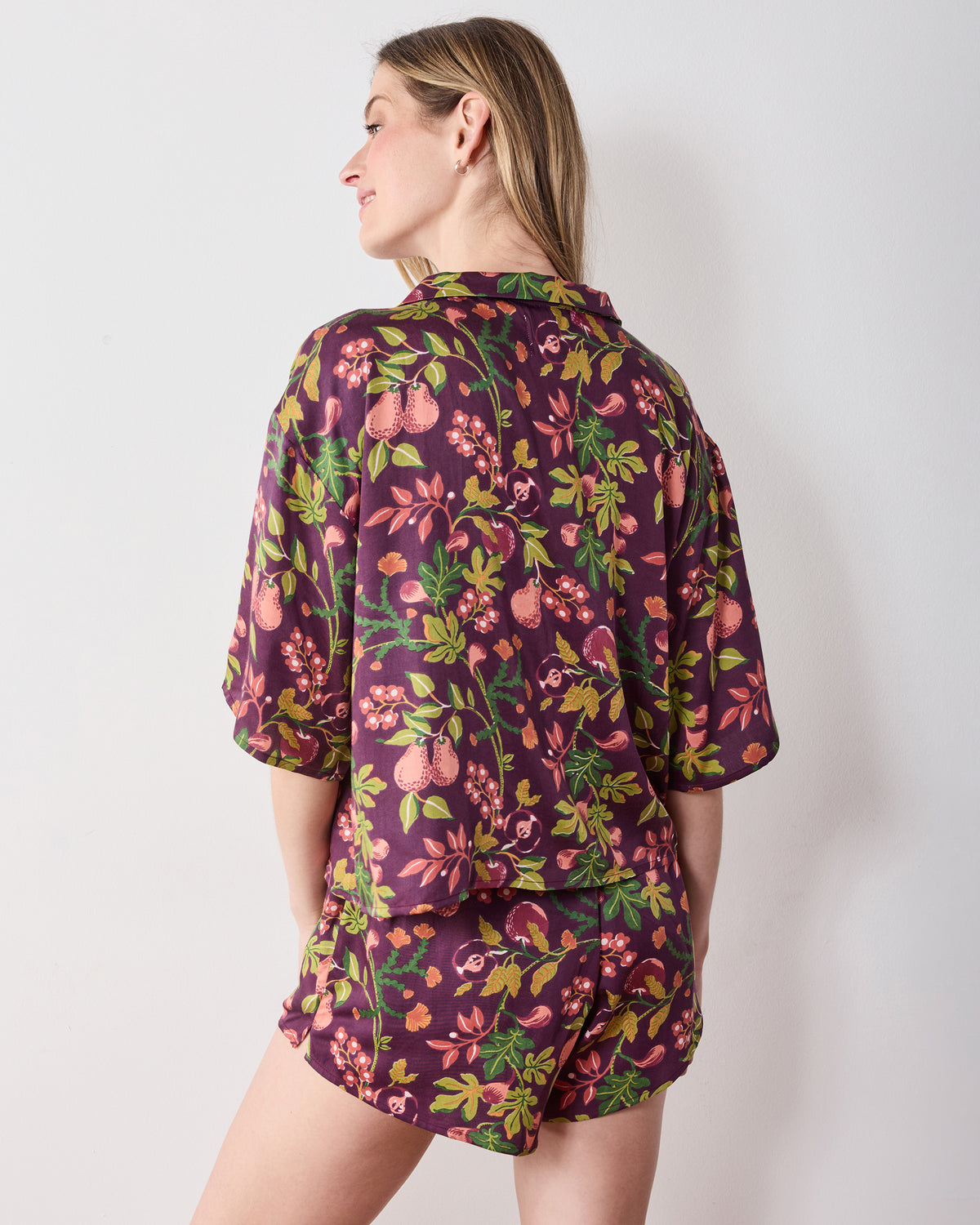 Back view of the plum Pomme & Poire Sweet Dreams short pajama set with a fruit-and-floral print.