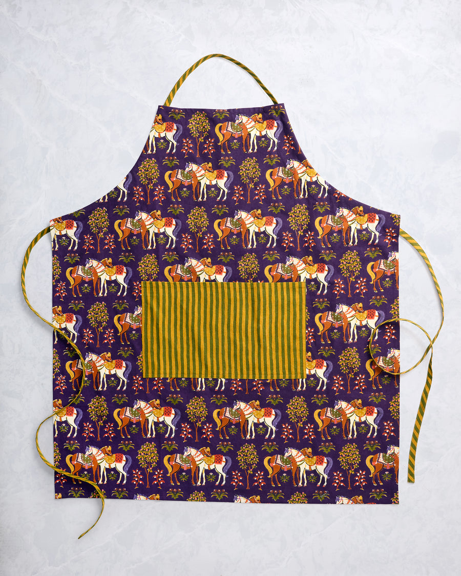 Deep aubergine apron with a repeating decorated-horse and tree print, front pocket, and adjustable ties.