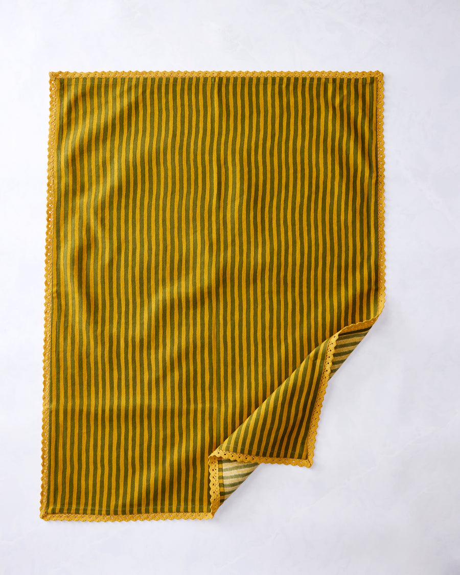 Green and gold vertically striped kitchen towel with scalloped trim and one corner folded back.