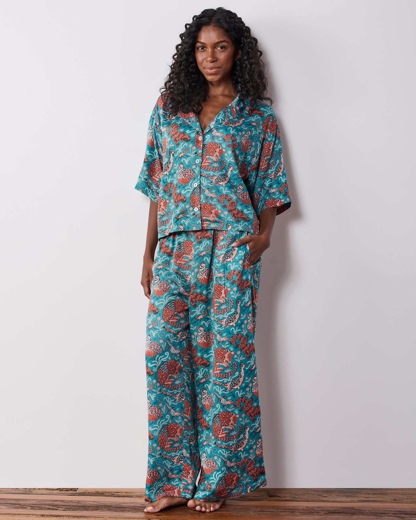 Front view of a teal patterned pajama set with a button-front top and wide-leg pants.