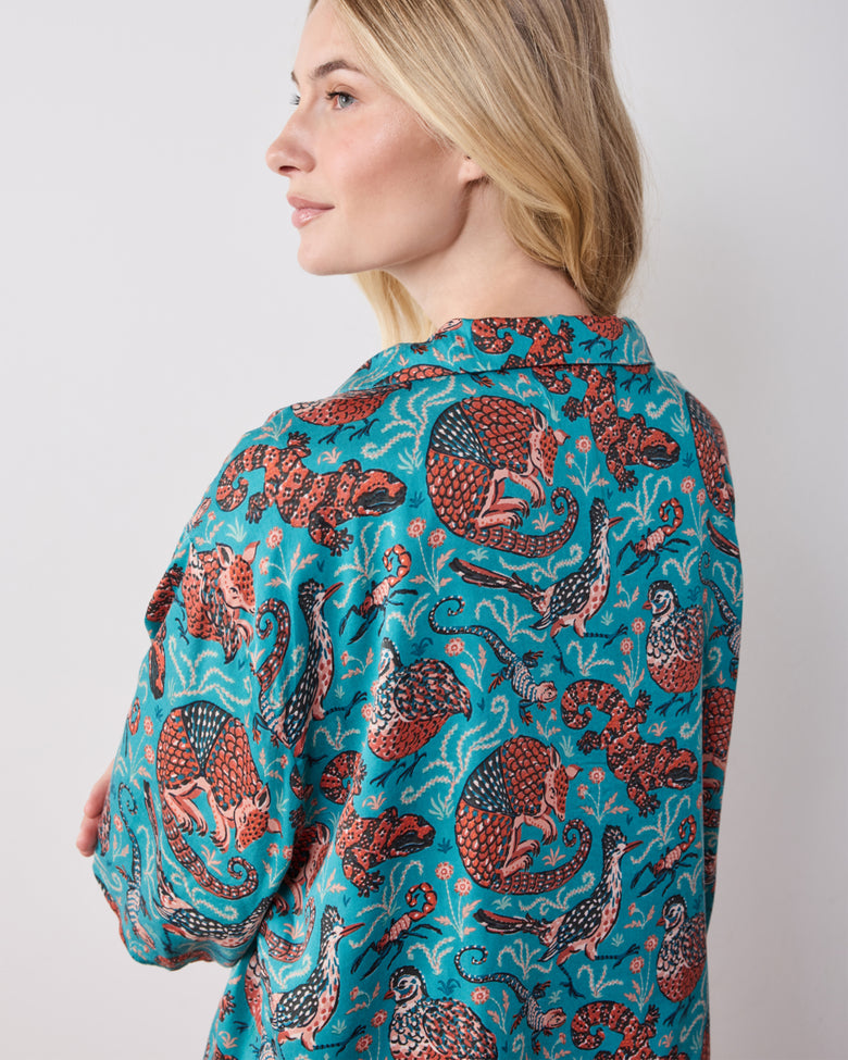 Close-up rear view of the teal pajama top with a multicolored animal and plant pattern.