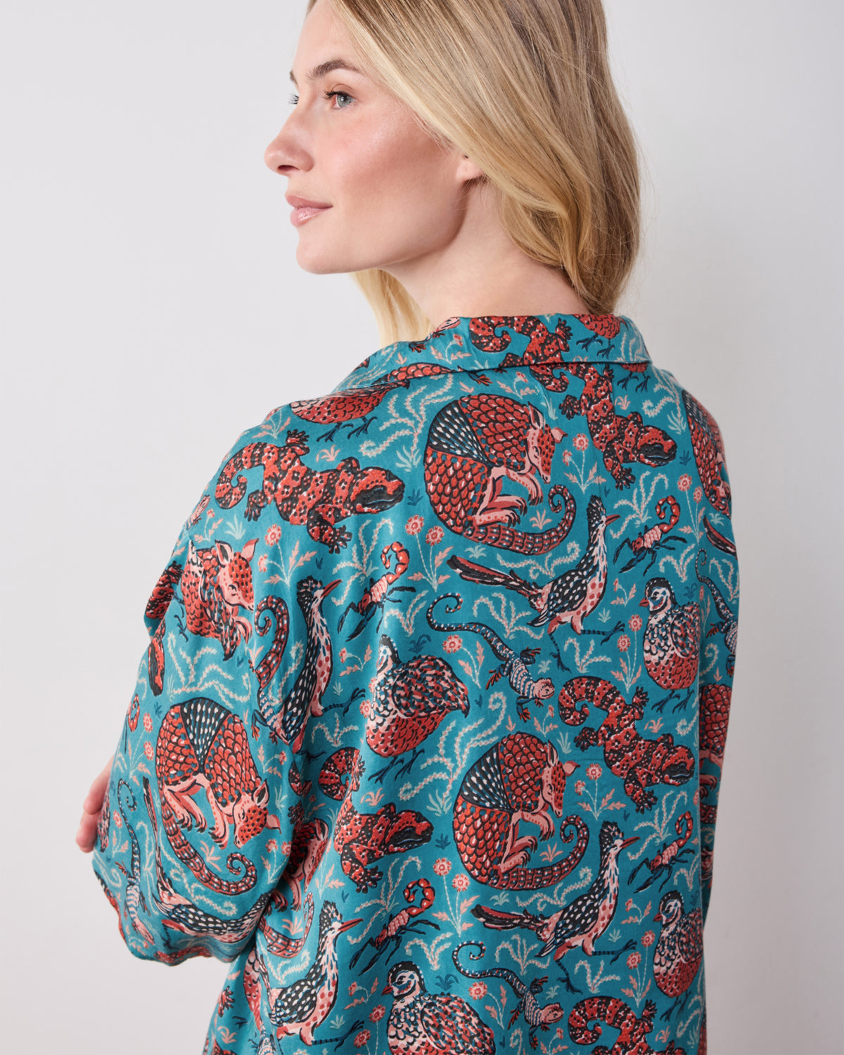 Close back view of the teal Canyon Critters pajama top showing its collar and animal print.