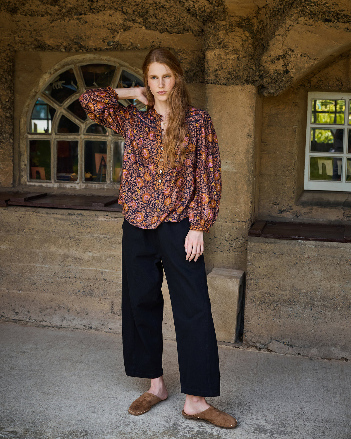 Full-length view of the Sunset Vine Evelyn blouse with long sleeves and gathered cuffs, paired with black wide-leg pants.