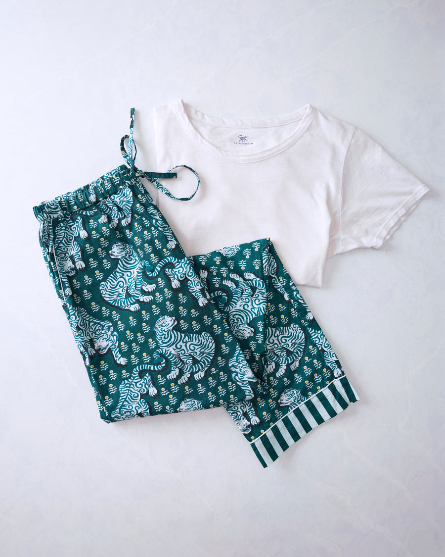 Green patterned pajama pants with illustrated tigers beside a white short-sleeve tee.