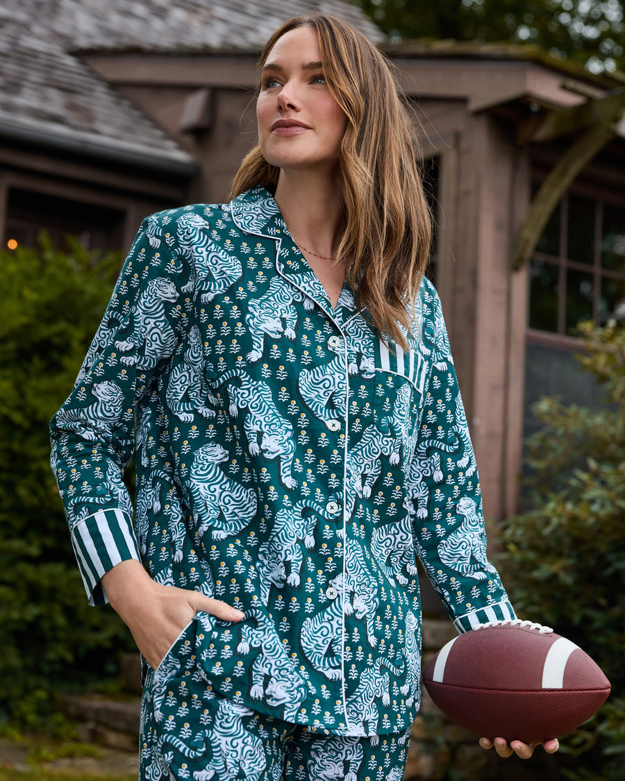 Close-up of the Game Day Green Tiger Queen pajama top with tiger print, white piping, button front, striped pocket and cuffs, and a football.
