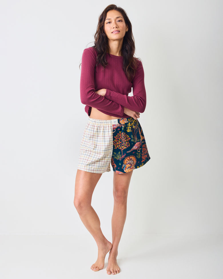 Full-length view of a person wearing the Navy Turkey Trot Boyfriend Boxer shorts with contrasting white plaid and navy turkey-print panels.