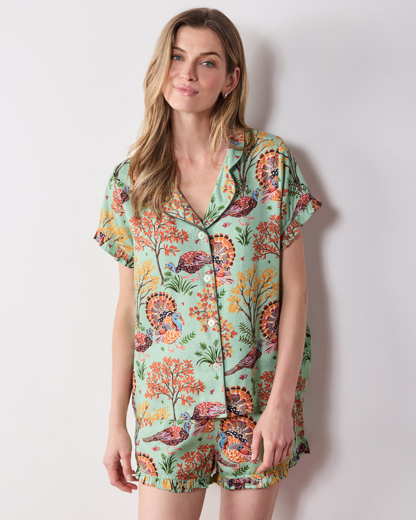 Front view of the Soft Sage Turkey Trot short pajama set with a collared, button-front ruffled top and matching printed shorts.