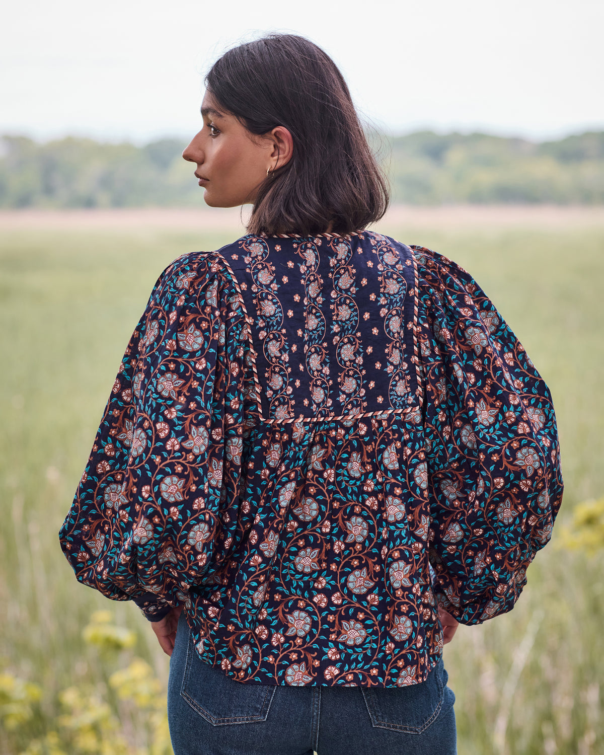 Back view of the Valley Garden Josephine blouse, showing its floral print, full sleeves, and billowy shape.