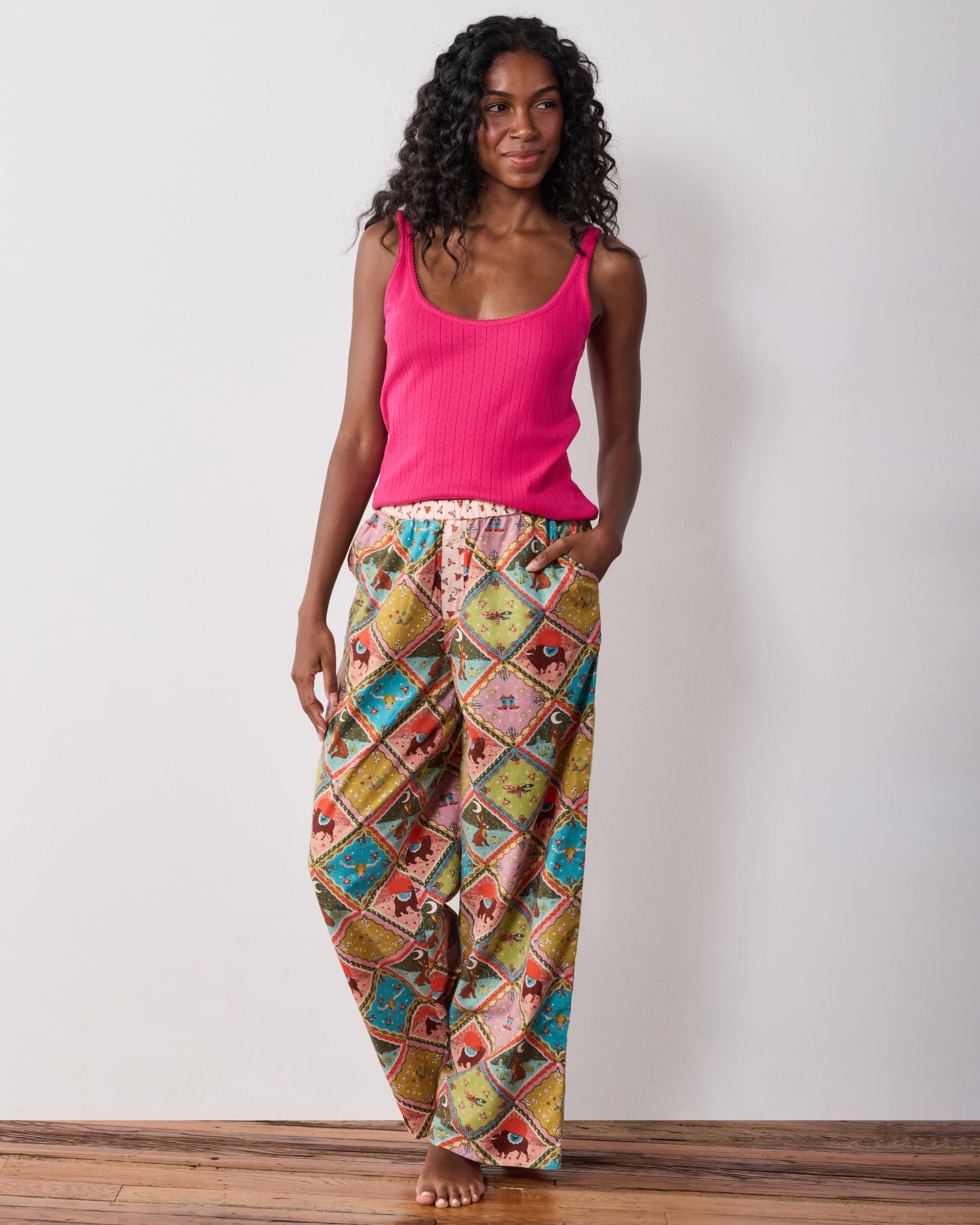 Front view of the Western Scenes wide-leg pajama pants worn with a pink tank top, showing the colorful animal and western-themed print.