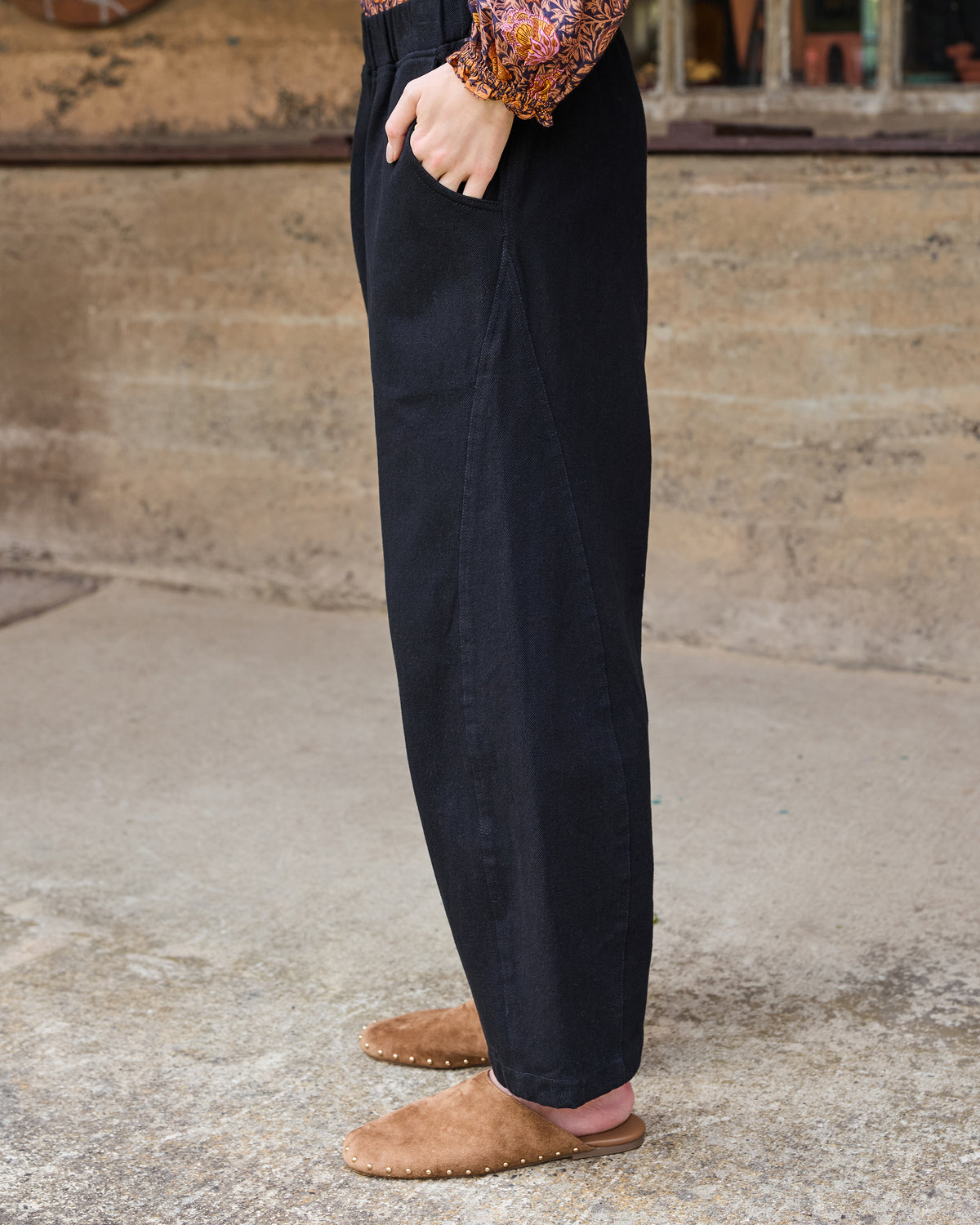 Side view of the Wilder Pant showing the straight wide-leg silhouette, elastic waistband, and side pocket.