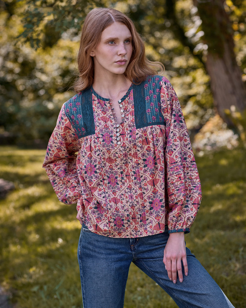 Model wearing the Winged Tapestry Denver blouse, shown from the front with its floral print, blue yoke panels, button placket, and gathered sleeves.