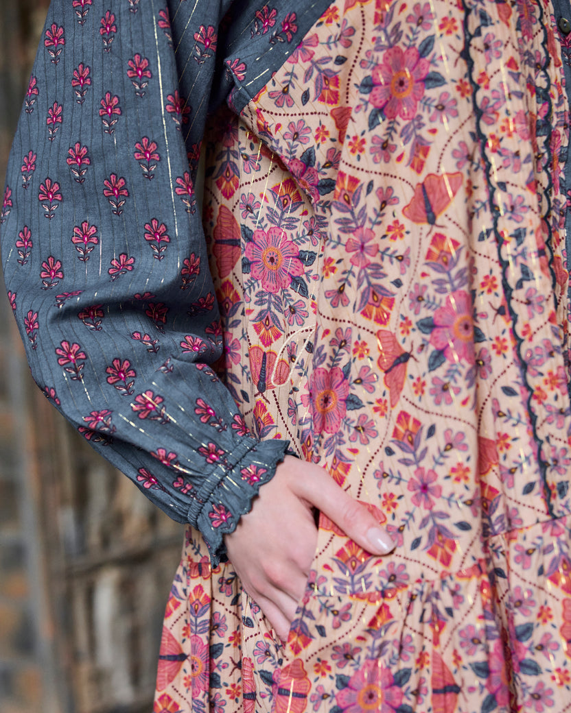 Close-up of the Lauren Dress showing the blue patterned sleeve, elastic cuff, and floral-print body.