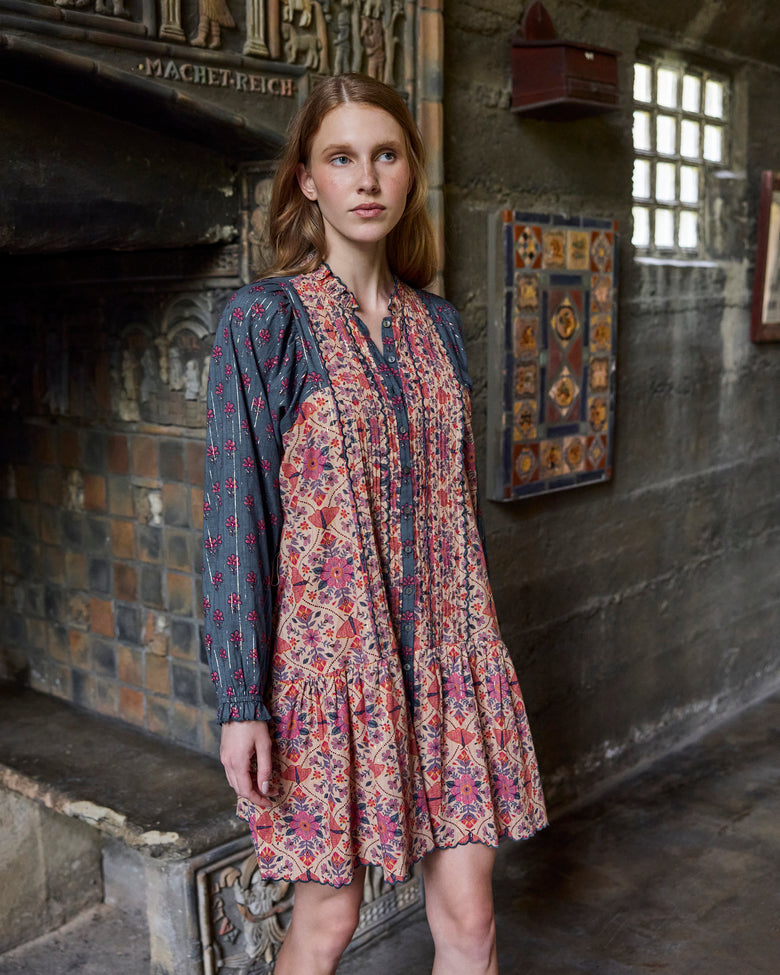 Front three-quarter view of the Winged Tapestry Lauren dress, showing its floral patterned bodice, dark floral sleeves, button placket, and flared skirt.