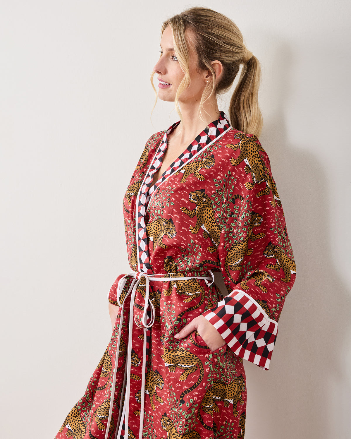 Side view of a model wearing the Scarlet Bagheera leopard-print robe with contrasting diamond trim, tie belt, and pocket.