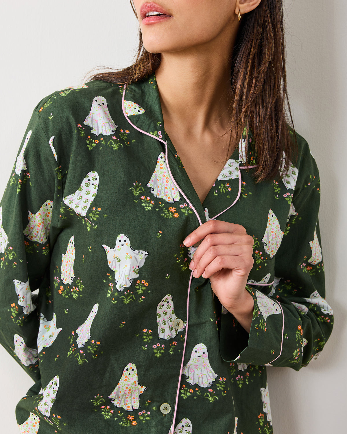 Close view of the Gardening Ghosts pajama top showing the notched collar, button front, contrasting piping, and ghost-and-flower print.