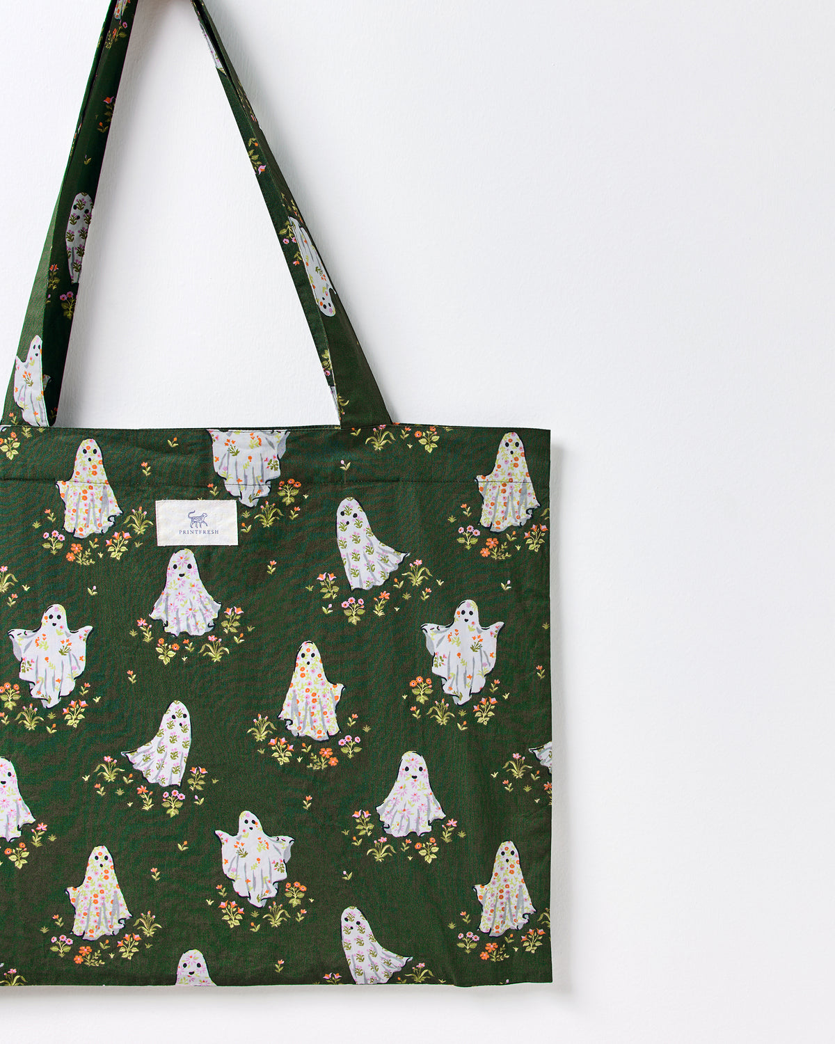 Close-up of a ghost-print tote bag showing its handle, upper edge, and PRINTFRESH label.