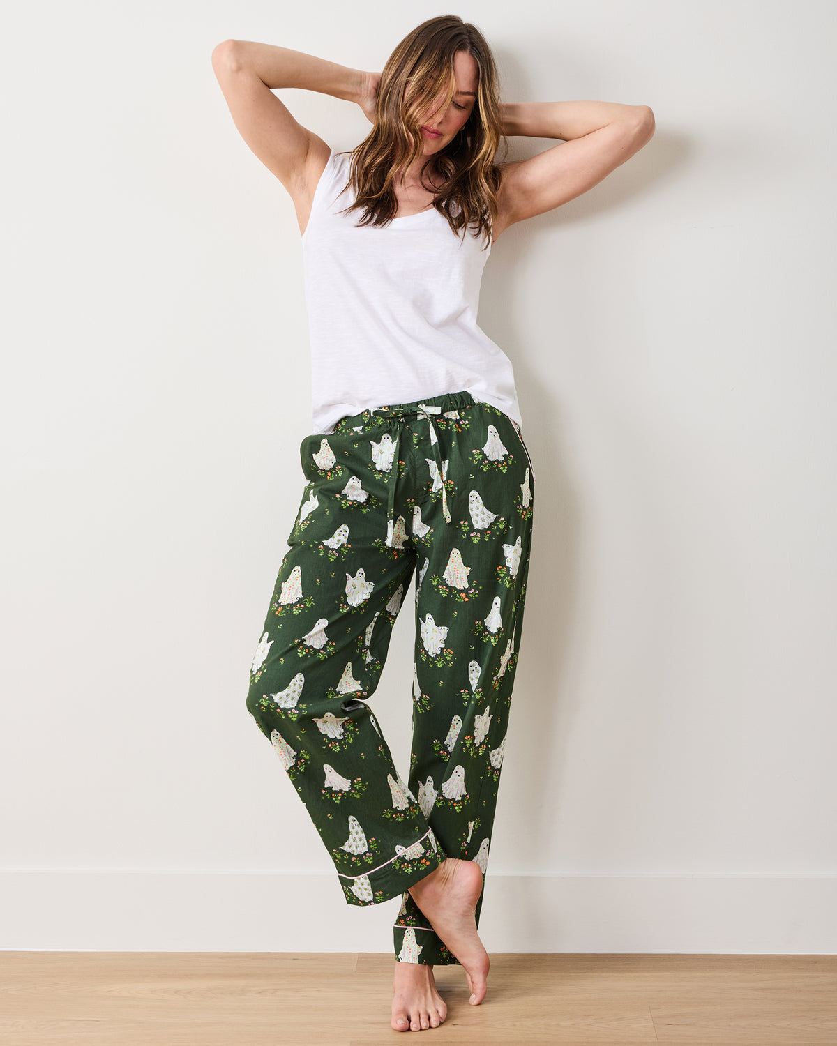 Rear three-quarter view of a person wearing Overgrown Moss Gardening Ghosts pajama pants with an allover ghost-and-flower print and contrasting cuff trim.