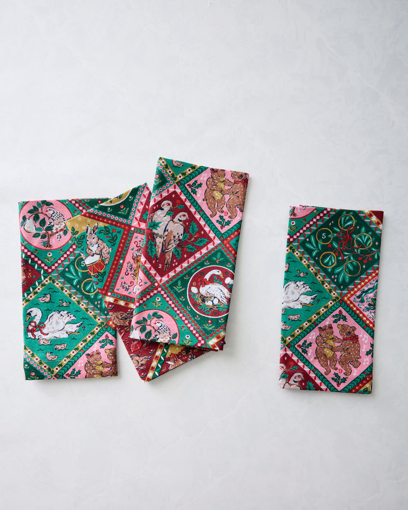 Four printed dinner napkins displayed separately to show the holiday pattern.