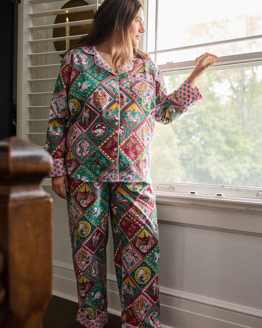 Person wearing a patterned long pajama set with a button-front shirt and matching pants.