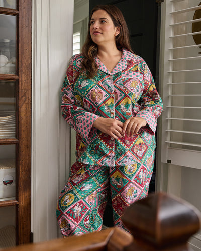 Front view of a person wearing a patterned button-front pajama shirt and matching pants.