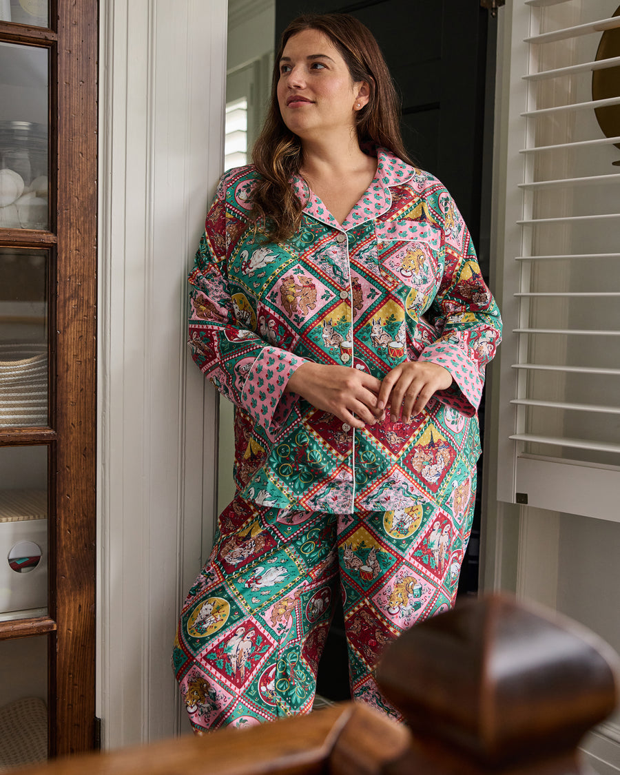 Front view of a person wearing a patterned button-front pajama shirt and matching pants.