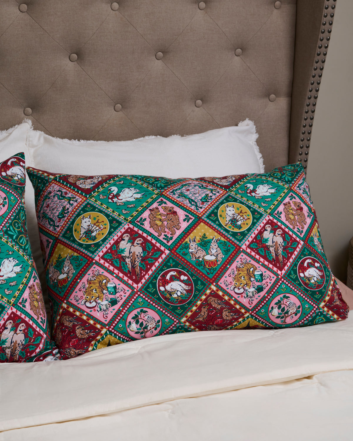 Christmas-themed pillowcases displayed on a bed, featuring colorful diamond-patterned illustrations of holiday scenes and animals.