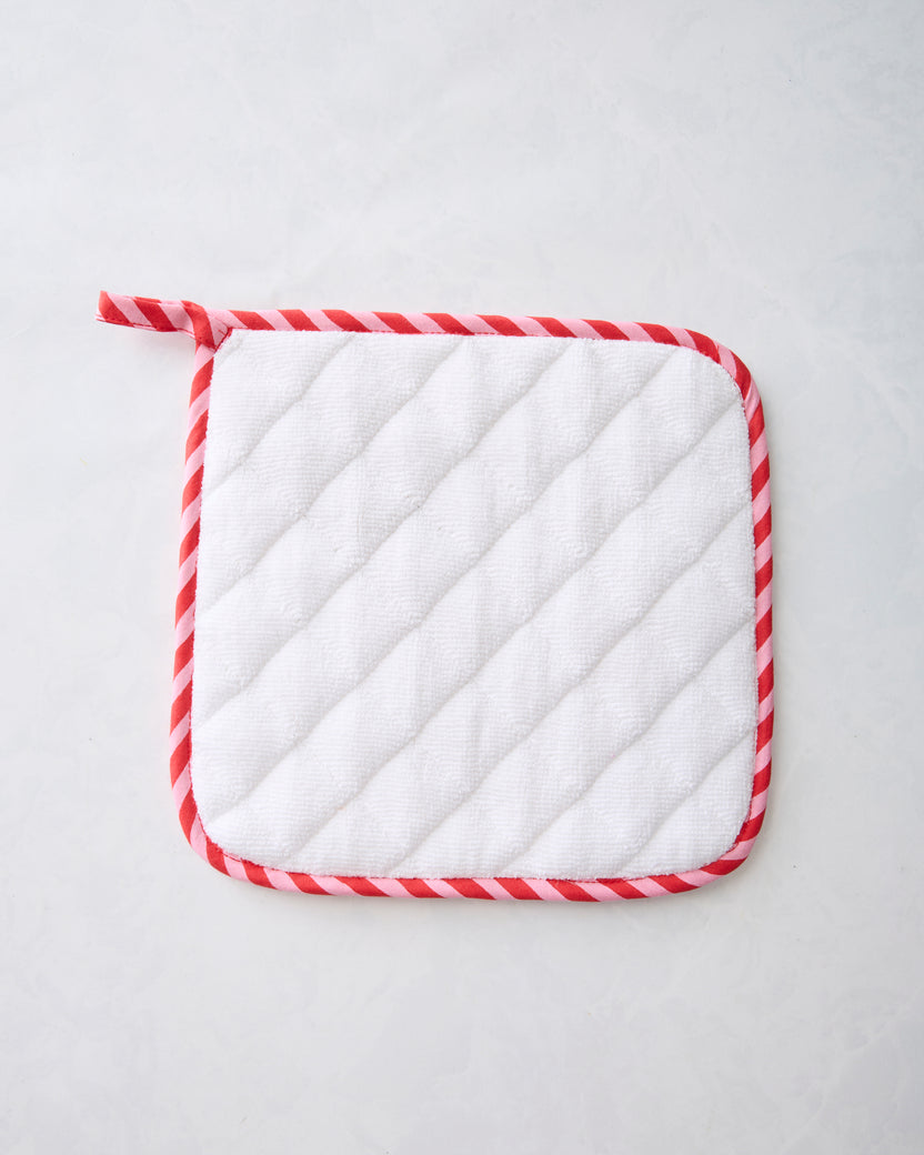 Back of a square pot holder with white diagonal quilting and red-and-white striped edging.
