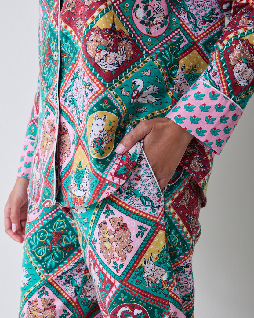 Close detail of the patterned long pajama set showing the button-front top, matching pants, and side pocket.
