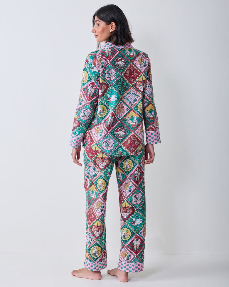 Full-length back view of the long-sleeved pajama top and matching pants with an allover holiday animal print.