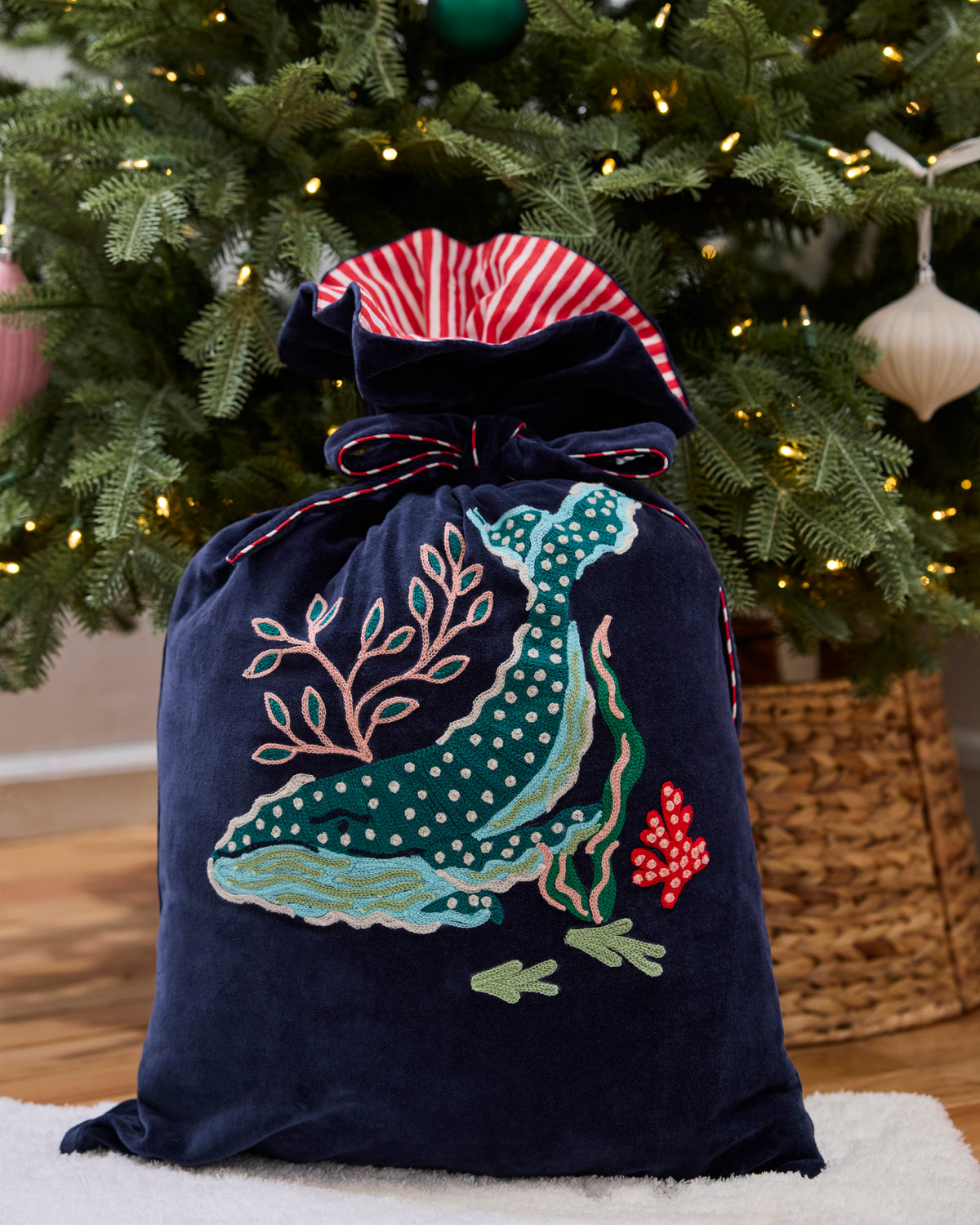 Blue Chill embroidered gift sack with a sealife motif and drawstring closure in front of a decorated Christmas tree