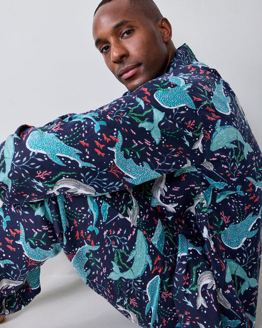 Close-up of a model wearing the Blue Chill Arctic Sea Life pajama set with a navy shirt covered in colorful aquatic and sea-life prints.