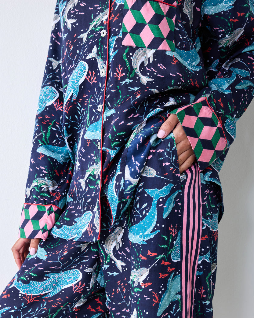 Close-up of a person wearing the Arctic Sea Life Rittenhouse pajama set with a navy sea-life print, pink geometric cuffs, and a side pocket.