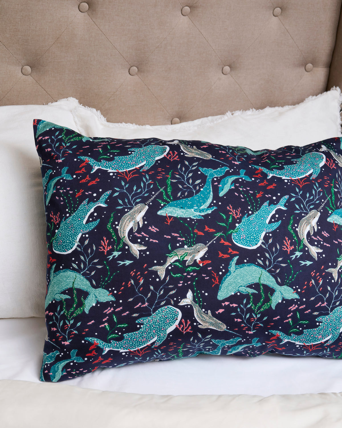 Arctic Sealife satin pillowcase displayed on a bed, with a dark navy underwater print of seals and other sea animals.
