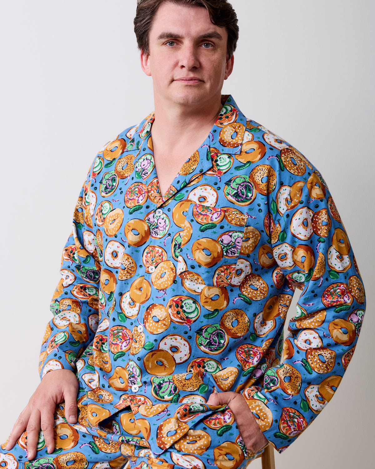 Close-up of a blue bagel-print pajama top with a notched collar and white buttons.