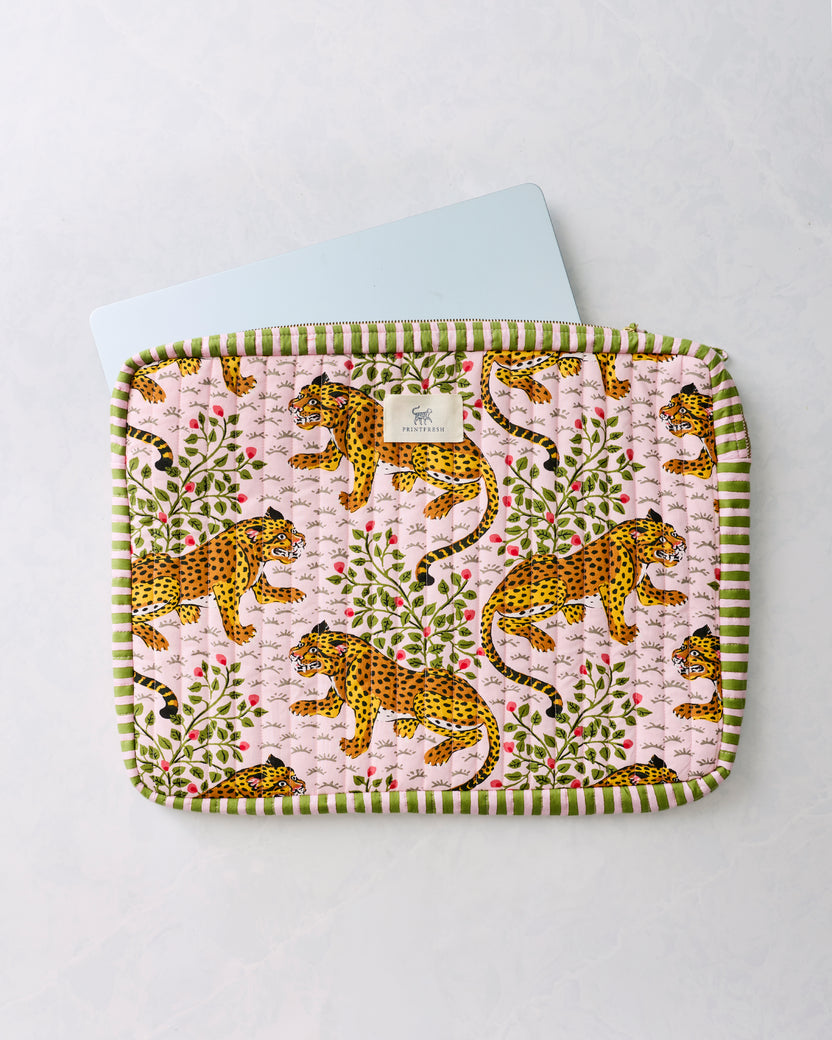 Pink leopard-print quilted laptop sleeve with green striped trim and a laptop partially visible inside