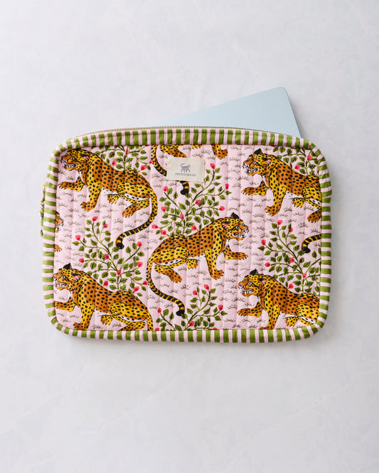 Quilted laptop sleeve with a leopard-and-floral print, green striped trim, and a laptop partly inserted at the top.