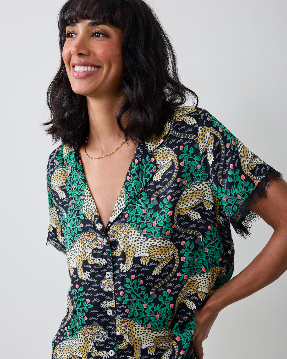 Model wearing the Bagheera Eco Satin Jackie Set top, featuring a dark leopard-and-botanical print, button front, short sleeves, and lace trim.