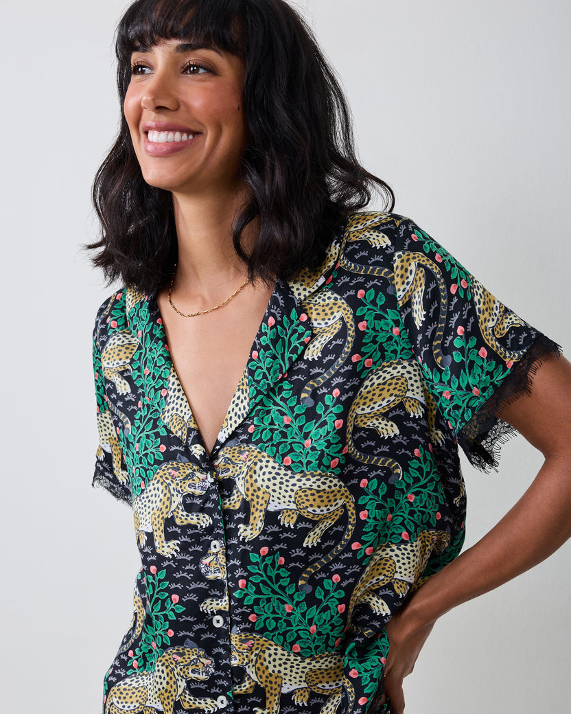 Model wearing the Bagheera Eco Satin Jackie Set top, featuring a dark leopard-and-botanical print, button front, short sleeves, and lace trim.