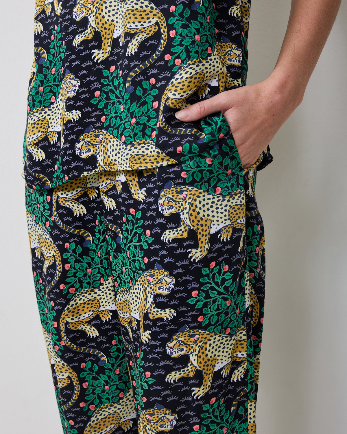 Close-up of the Bagheera Eco Satin Georgia Set pants, showing the leopard-and-leaf print and side pocket.