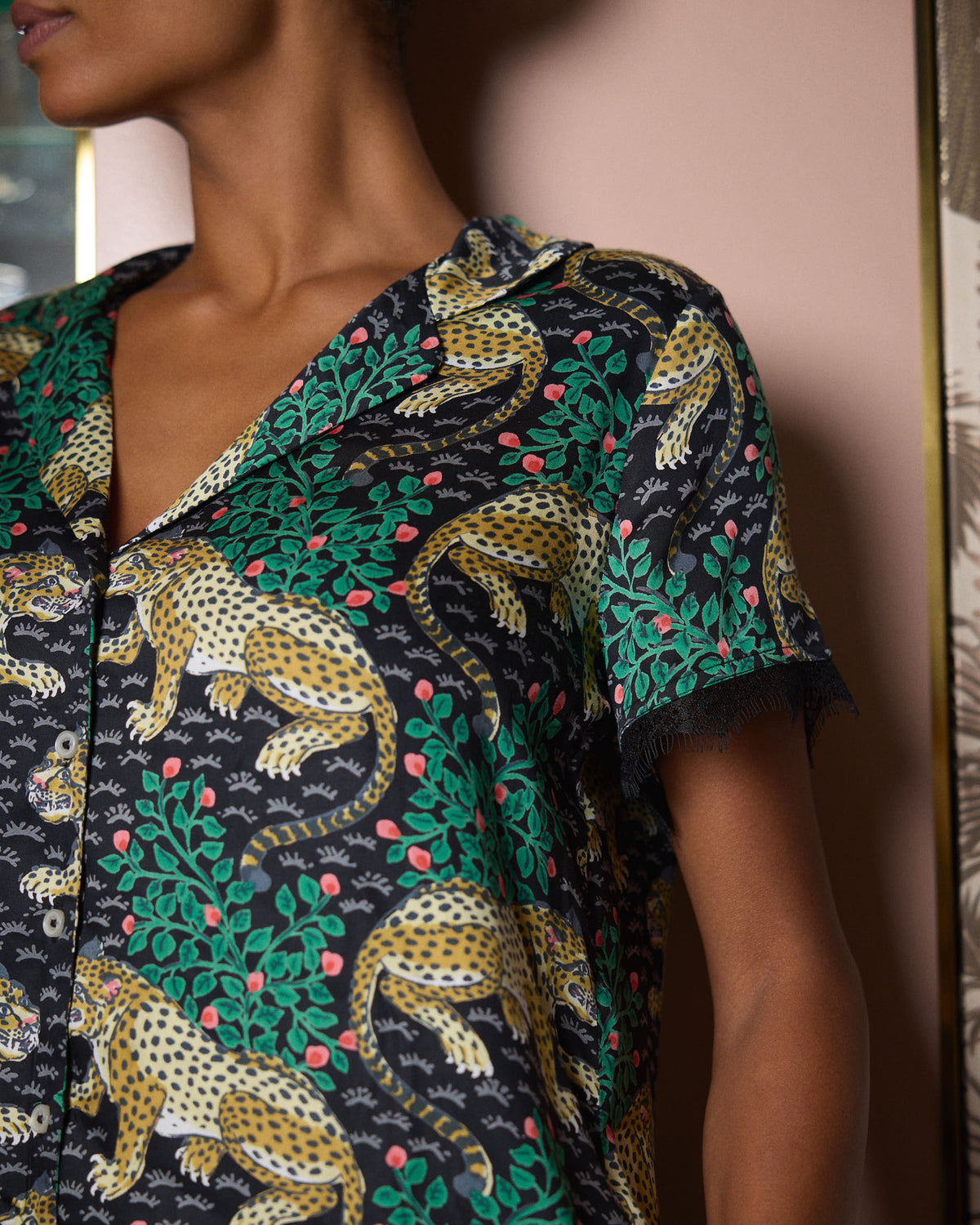 Close-up of the Bagheera Eco Satin Jackie Set showing the notched collar, buttons, leopard-and-foliage print, and lace-trimmed sleeve.