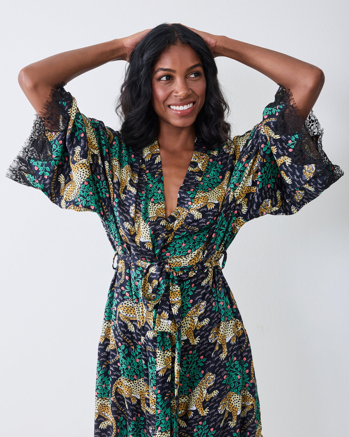Front view of the Bagheera Eco Satin Lace Robe in Ink with the wide lace-trimmed sleeves raised, showing the belted waist and leopard-and-foliage print.