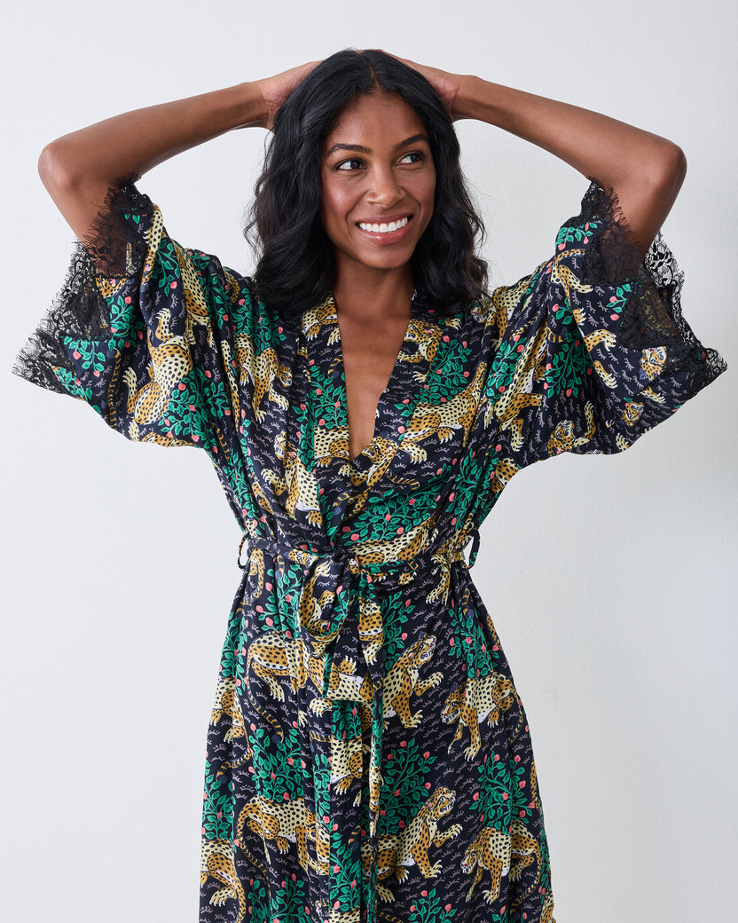 Front view of the Bagheera Eco Satin Lace Robe in Ink with the wide lace-trimmed sleeves raised, showing the belted waist and leopard-and-foliage print.