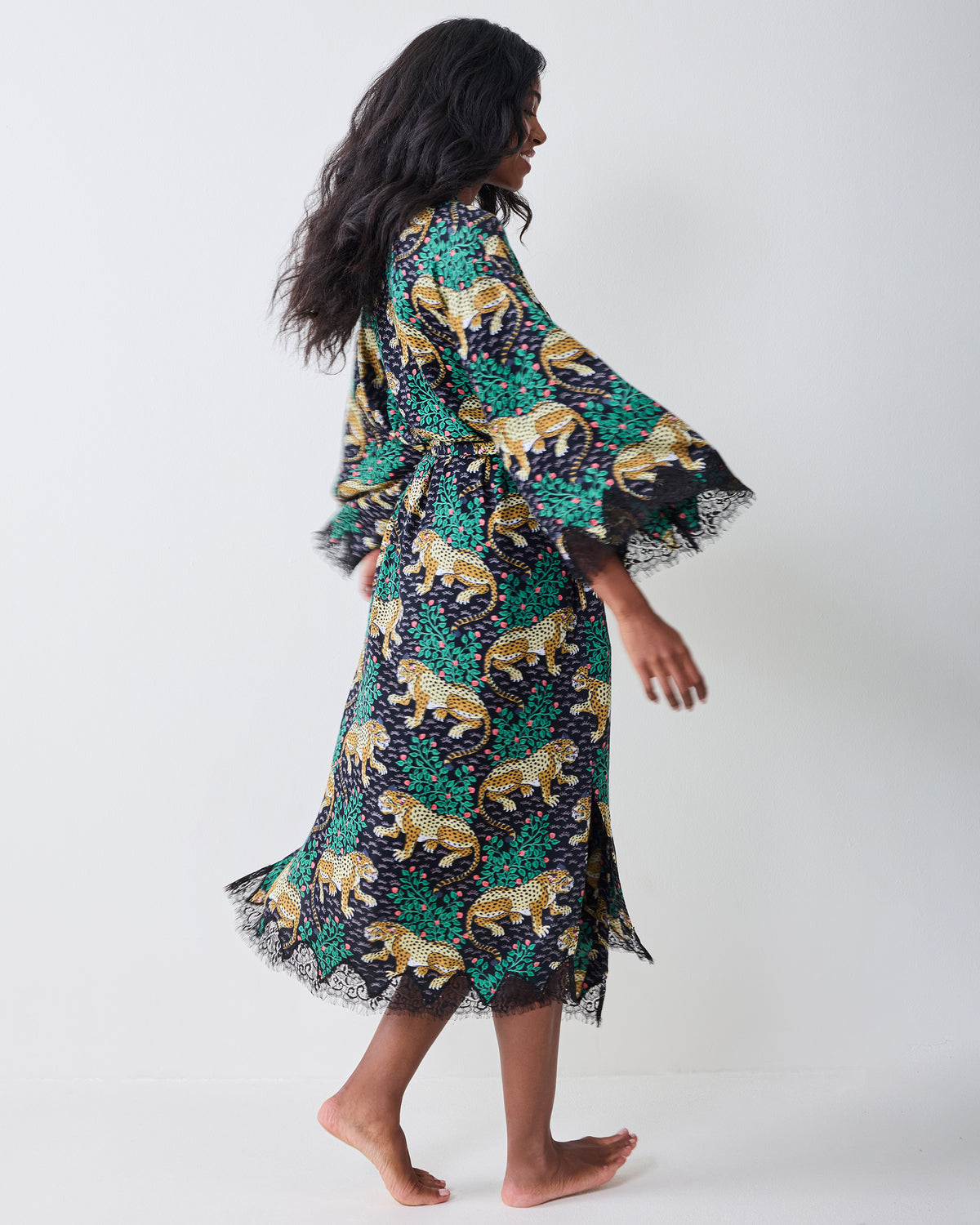 Side and back view of the Bagheera Eco Satin Lace Robe in Ink, showing its leopard-and-foliage print, belted waist, wide sleeves, and lace trim.