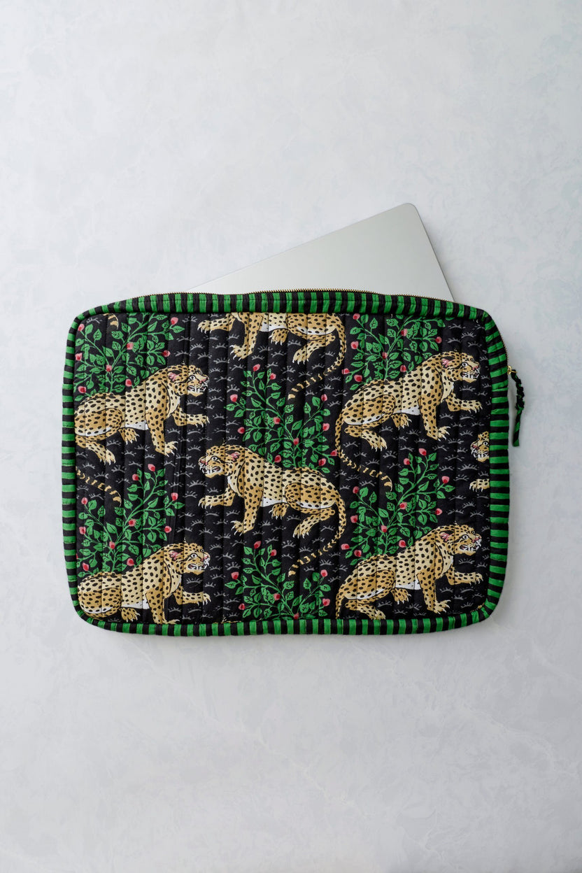 Bagheera Ink quilted laptop sleeve shown open with a white laptop partially inside; leopard and leafy print covers the sleeve.