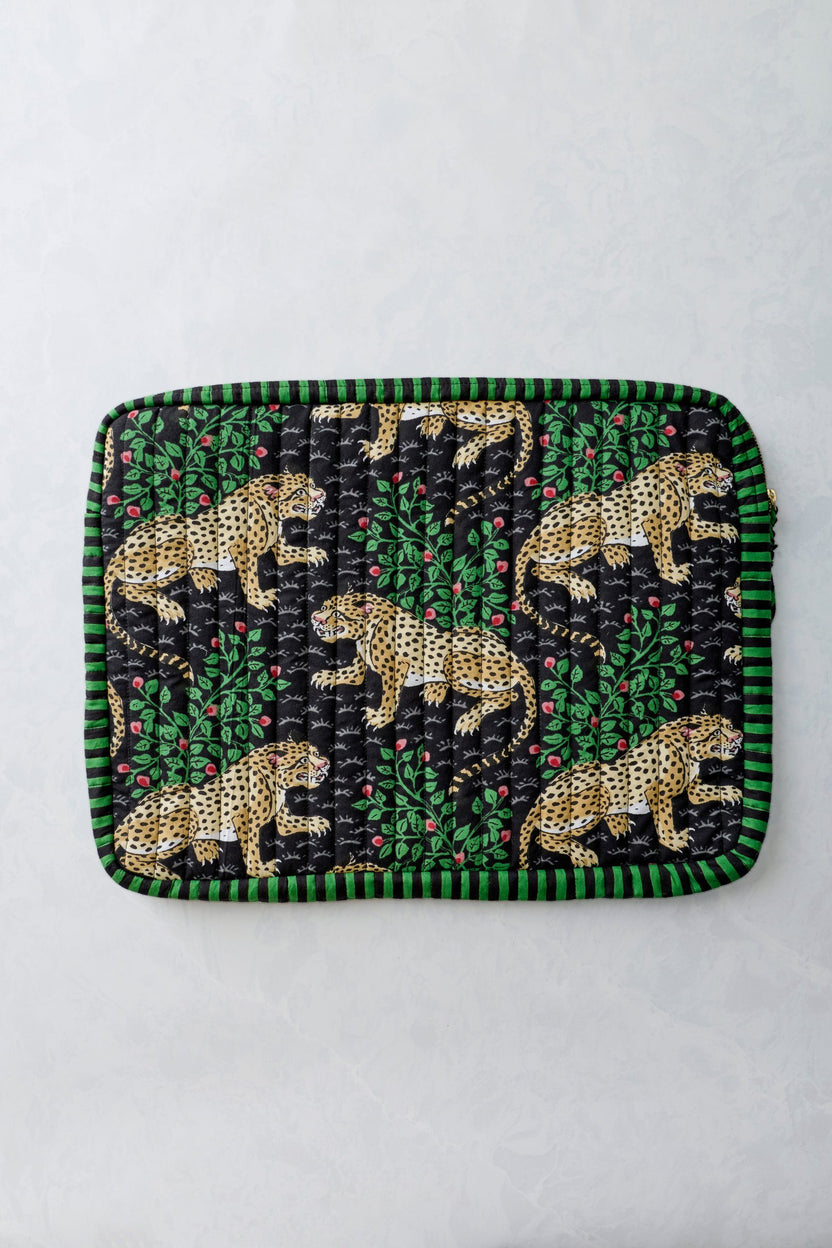 Front view of the Bagheera Ink quilted laptop sleeve with leopard and leafy print and a green-and-black striped border.