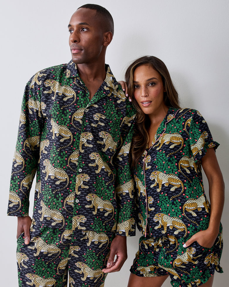Two people pose together wearing matching Bagheera leopard-print pajamas; one wears the ink ruffle short set and the other wears a long-sleeved pajama set.