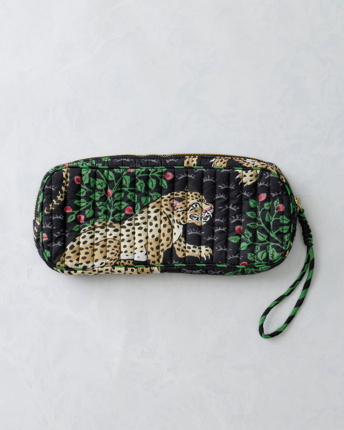 Back view of the Bagheera Ink quilted zippered sunglasses case with a leopard print panel and wrist loop.